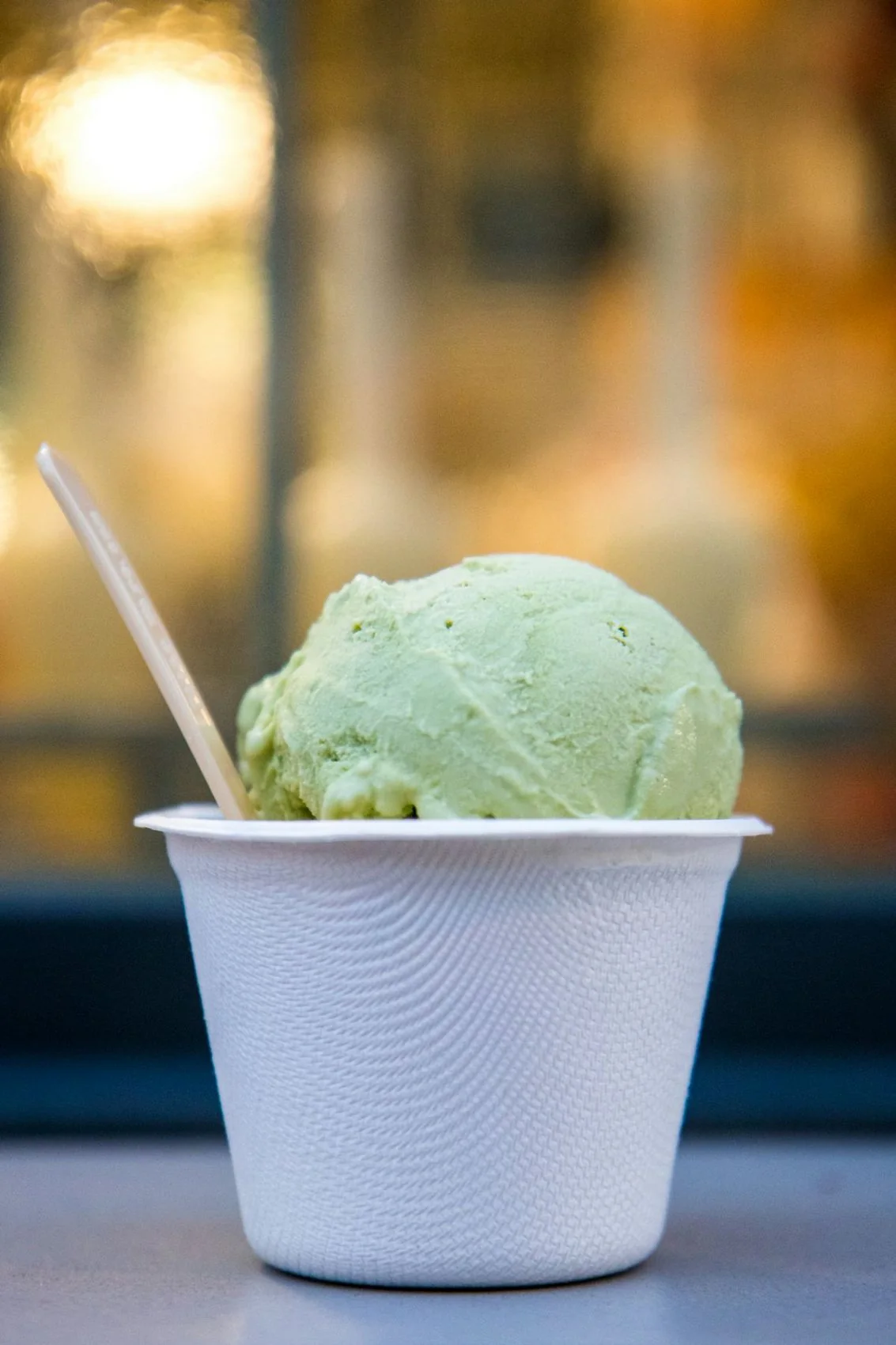 A cup of ice cream with a wooden spoon